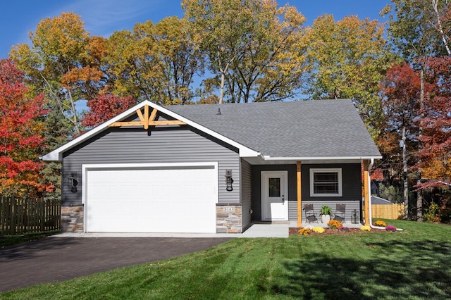 view of front of home featuring a garage, a front yard, and covered porch