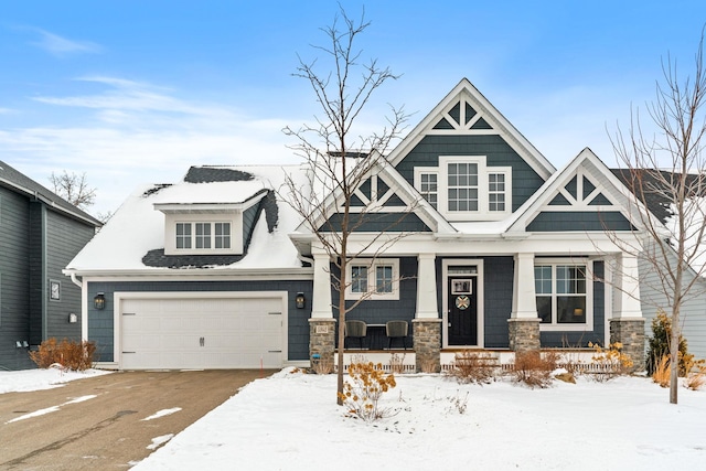 craftsman inspired home featuring a garage, stone siding, and a porch