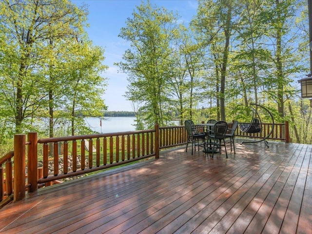 wooden terrace featuring a water view and outdoor dining space