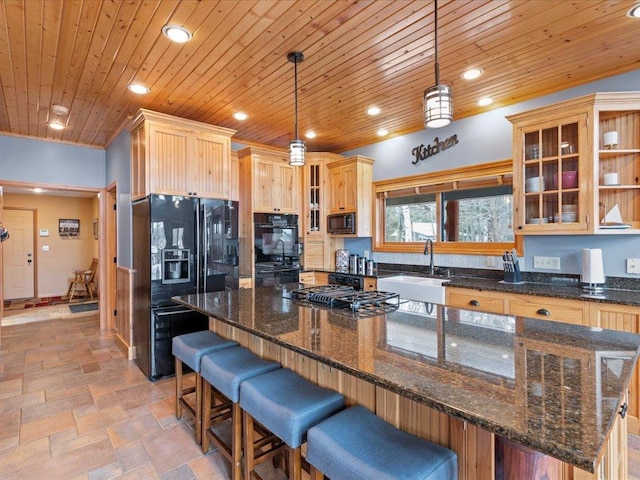 kitchen with black appliances, a sink, wooden ceiling, recessed lighting, and a kitchen breakfast bar