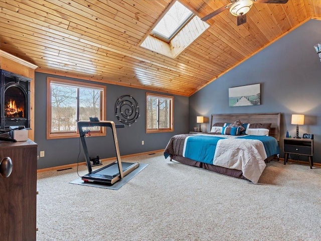 carpeted bedroom featuring vaulted ceiling, wood ceiling, a skylight, and baseboards