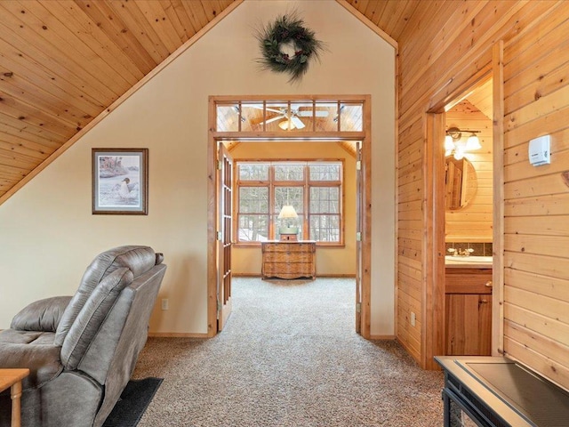 carpeted home office with vaulted ceiling, wooden ceiling, wood walls, ceiling fan, and baseboards