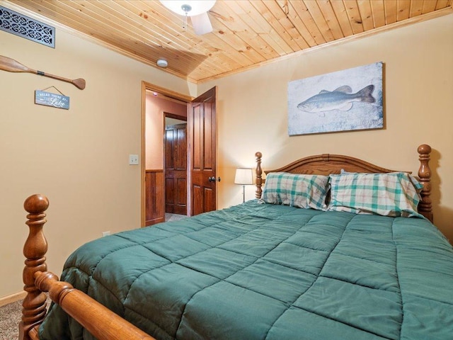 bedroom featuring crown molding, wood ceiling, and carpet flooring