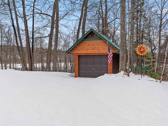 snow covered garage with a detached garage
