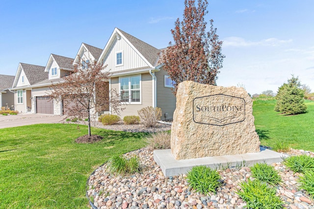 community / neighborhood sign with a lawn, a garage, and concrete driveway