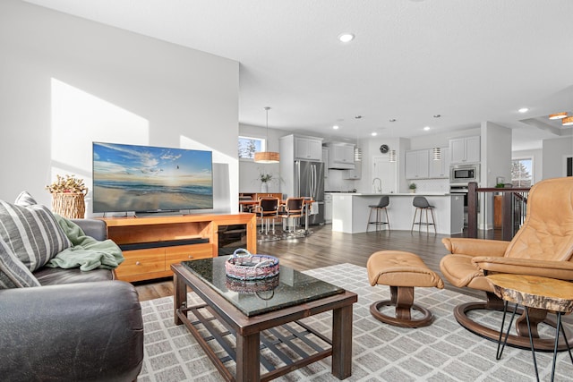 living area with light wood-style floors and recessed lighting