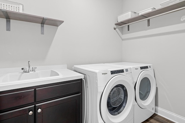 laundry area featuring cabinet space, washing machine and clothes dryer, dark wood finished floors, and baseboards