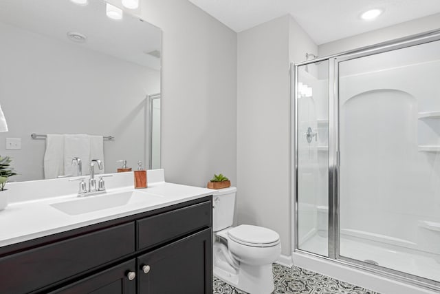 bathroom with a shower stall, toilet, vanity, recessed lighting, and tile patterned flooring