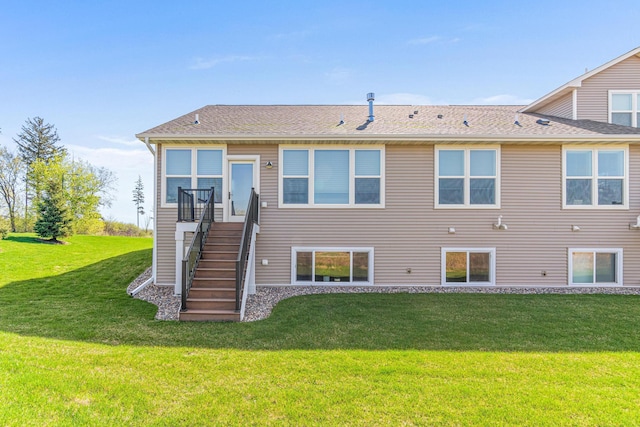back of property featuring a lawn, stairway, and a shingled roof