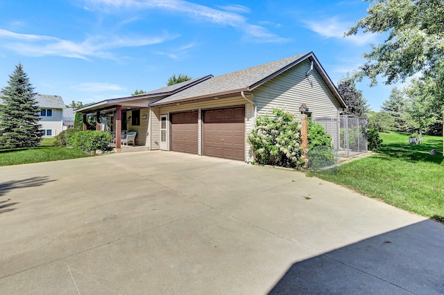 view of side of property with a garage and a lawn