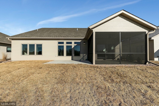 back of house with a patio area, a sunroom, and a lawn