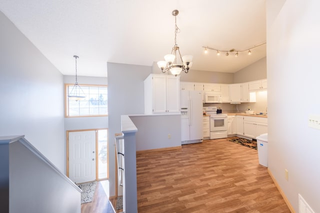 kitchen featuring white cabinetry, light wood-type flooring, pendant lighting, and white appliances