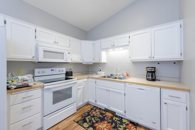 kitchen featuring lofted ceiling, sink, light wood-type flooring, white cabinets, and white appliances