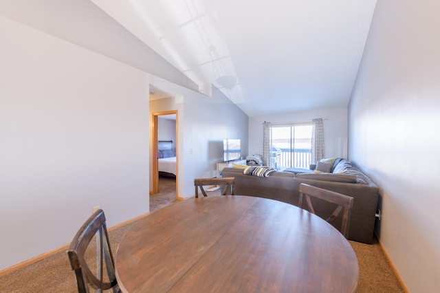 dining area with lofted ceiling and light colored carpet