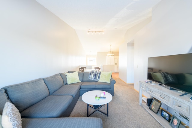 carpeted living room with high vaulted ceiling, rail lighting, and a chandelier