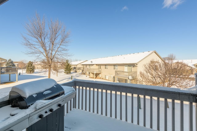 snow covered back of property featuring a grill