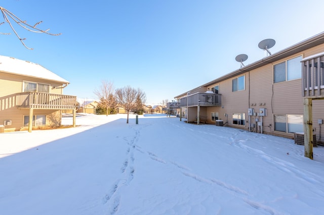 yard layered in snow with a balcony