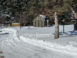 yard covered in snow with a storage unit