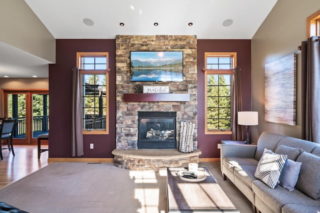 living room featuring baseboards, a fireplace, and a healthy amount of sunlight