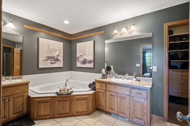 bathroom with two vanities, a sink, a bath, and tile patterned floors