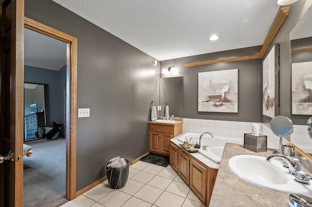 bathroom featuring tile patterned flooring, a textured ceiling, vanity, and a bath