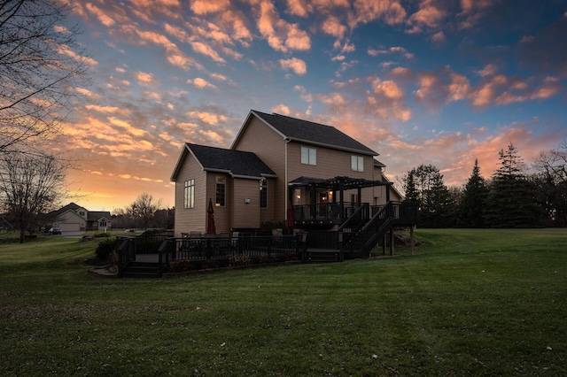 back of house with a pergola, a deck, and a lawn