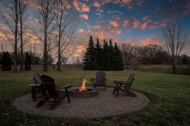 patio terrace at dusk with a yard and an outdoor fire pit