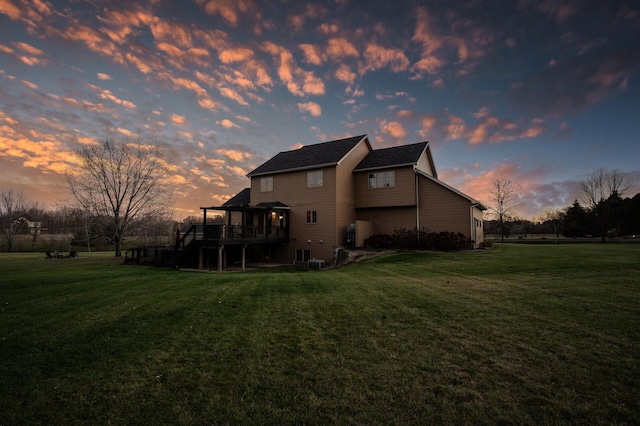 property exterior at dusk featuring a yard, a deck, and stairs