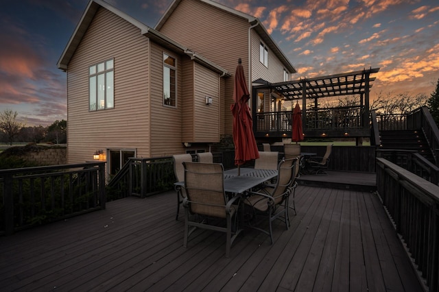 deck at dusk featuring outdoor dining area