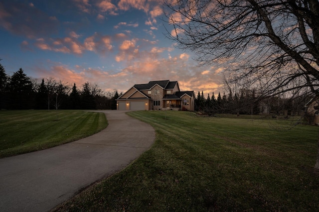 view of front facade with a garage, a lawn, and driveway