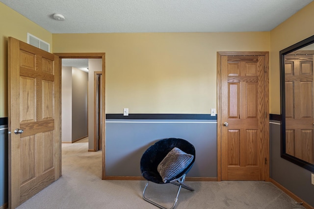 office featuring light carpet, a textured ceiling, visible vents, and baseboards