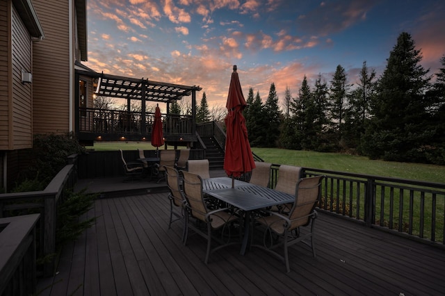 deck at dusk with a yard, stairs, a pergola, and outdoor dining space