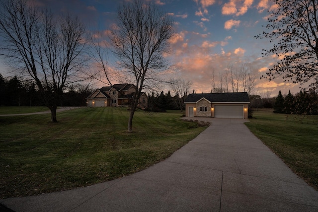 view of front facade with a garage, a yard, and concrete driveway