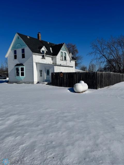 view of snow covered back of property