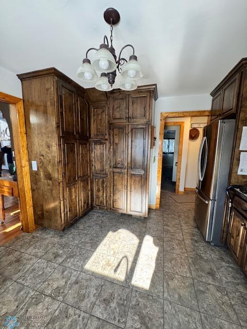 kitchen with stainless steel fridge, dark brown cabinets, and a notable chandelier