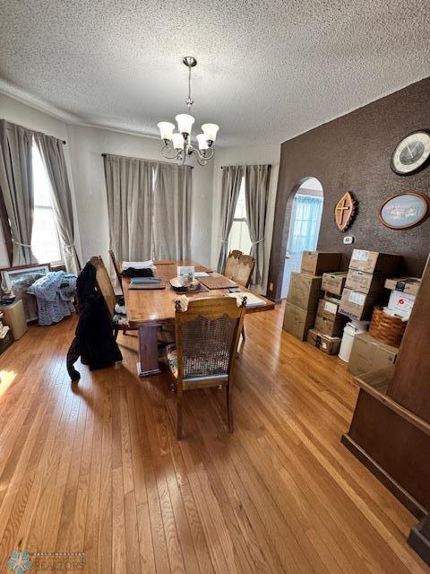 dining area featuring a textured ceiling, a chandelier, and light hardwood / wood-style flooring