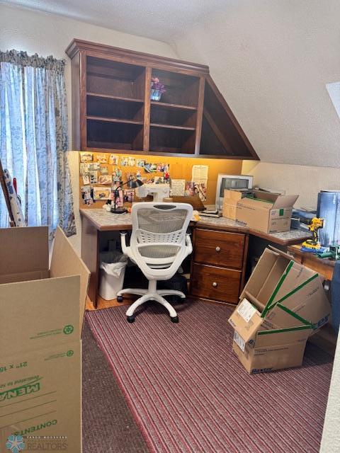 home office featuring lofted ceiling and a textured ceiling