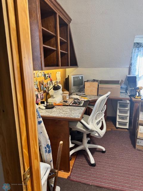 home office featuring vaulted ceiling and a textured ceiling