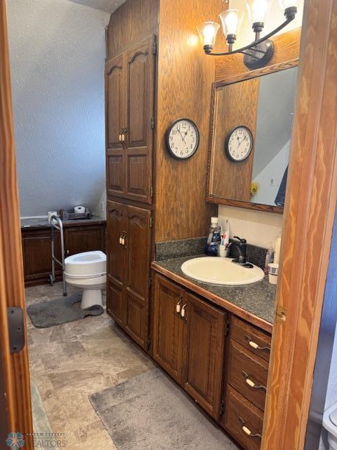 bathroom featuring vanity, a chandelier, and toilet