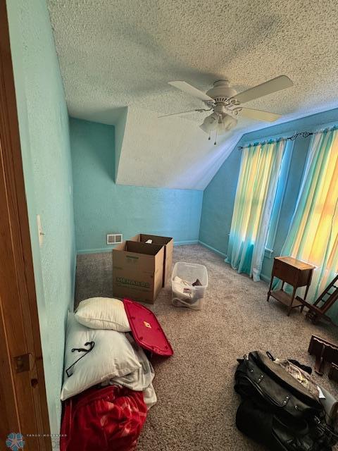 additional living space featuring carpet floors, ceiling fan, vaulted ceiling, and a textured ceiling