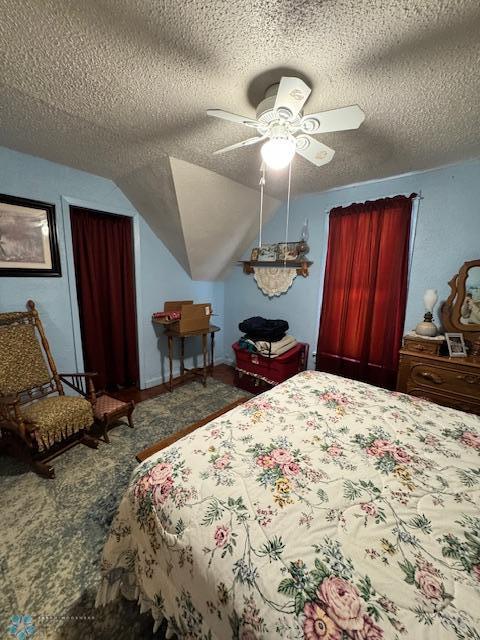 bedroom with ceiling fan, lofted ceiling, and a textured ceiling