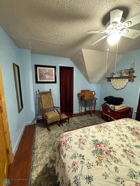 bedroom featuring ceiling fan, lofted ceiling, and a textured ceiling