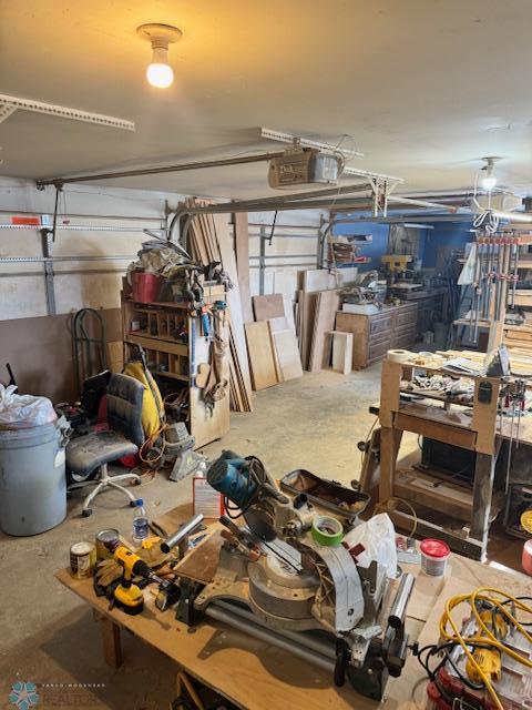 garage with a garage door opener and a workshop area