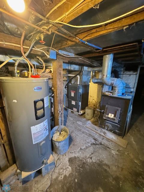 utility room featuring heating unit and water heater