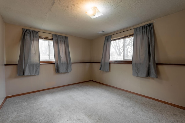carpeted spare room with a textured ceiling