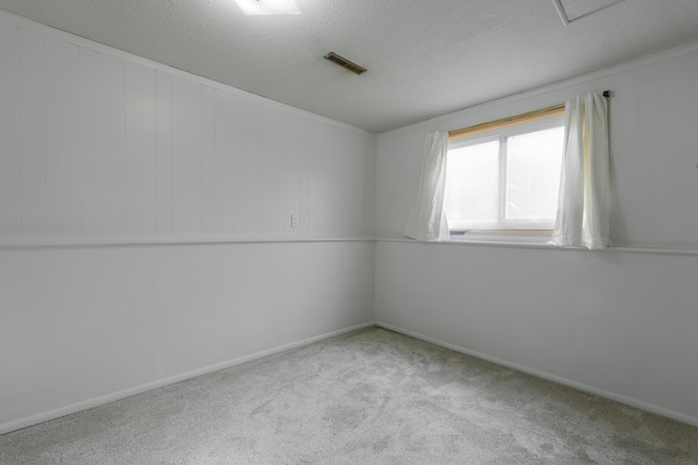 carpeted spare room with a textured ceiling