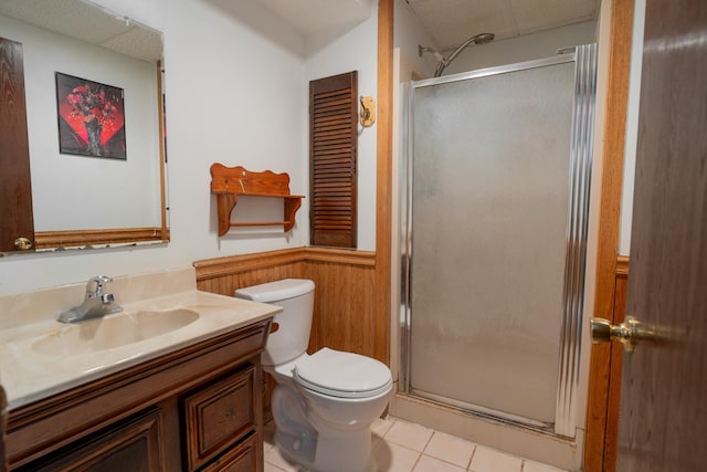 bathroom featuring a paneled ceiling, vanity, tile patterned floors, toilet, and walk in shower