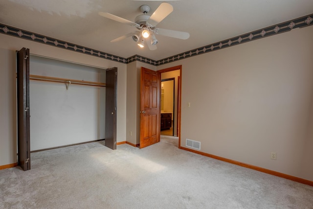 unfurnished bedroom featuring light colored carpet, a closet, and ceiling fan