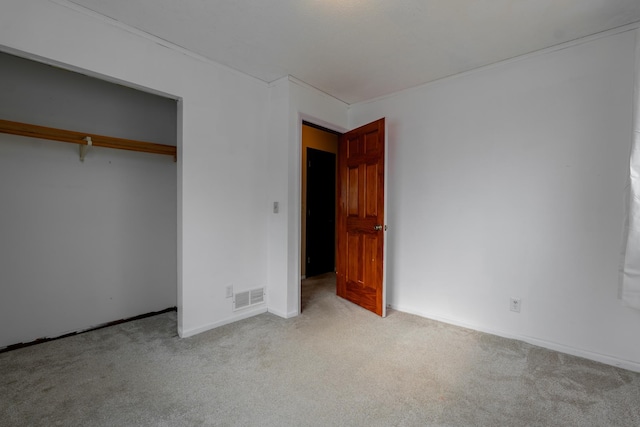 unfurnished bedroom with a closet and light carpet