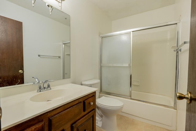 full bathroom featuring vanity, tile patterned flooring, bath / shower combo with glass door, and toilet